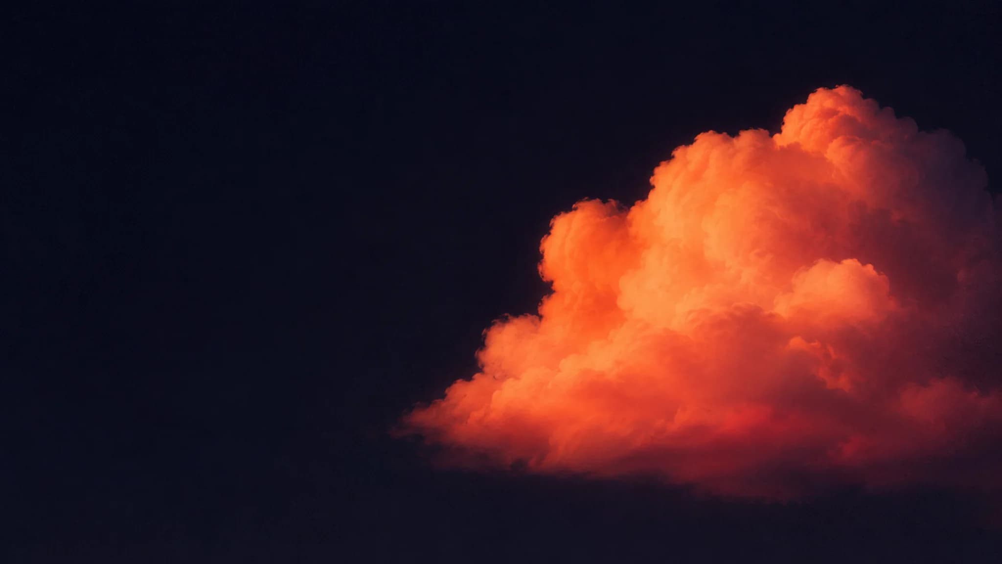 A single glowing orange cloud form floating in a deep ink sky